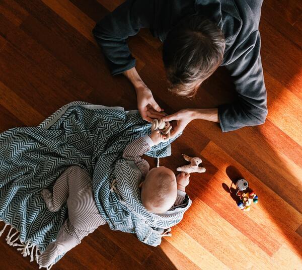 Mother and baby playing on a hardwood floor 
